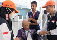 Petugas kesehatan memeriksa suhu tubuh jemaah haji yang baru tiba di bandara sebagai langkah deteksi dini penyebaran Covid-19.